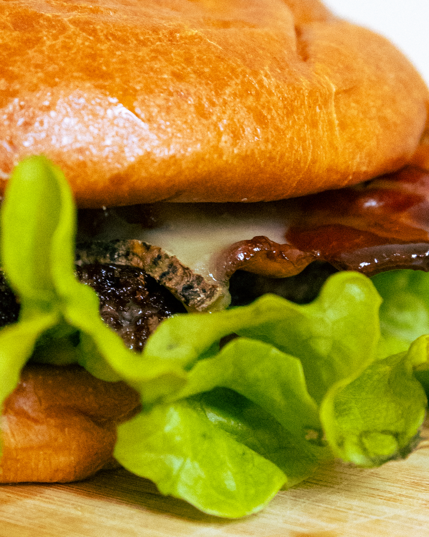 Un bacon burger délicieux avec son pain maison, sa salade fraîche et son fromage fondant.